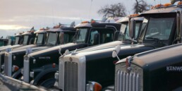 Trucking company owner reviewing fleet cost reports and per-mile financial data