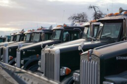 Trucking company owner reviewing fleet cost reports and per-mile financial data